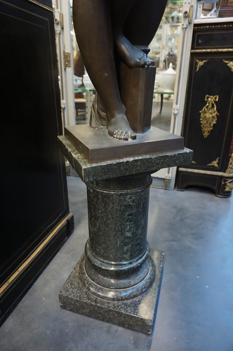 Big bronze nude on marble column