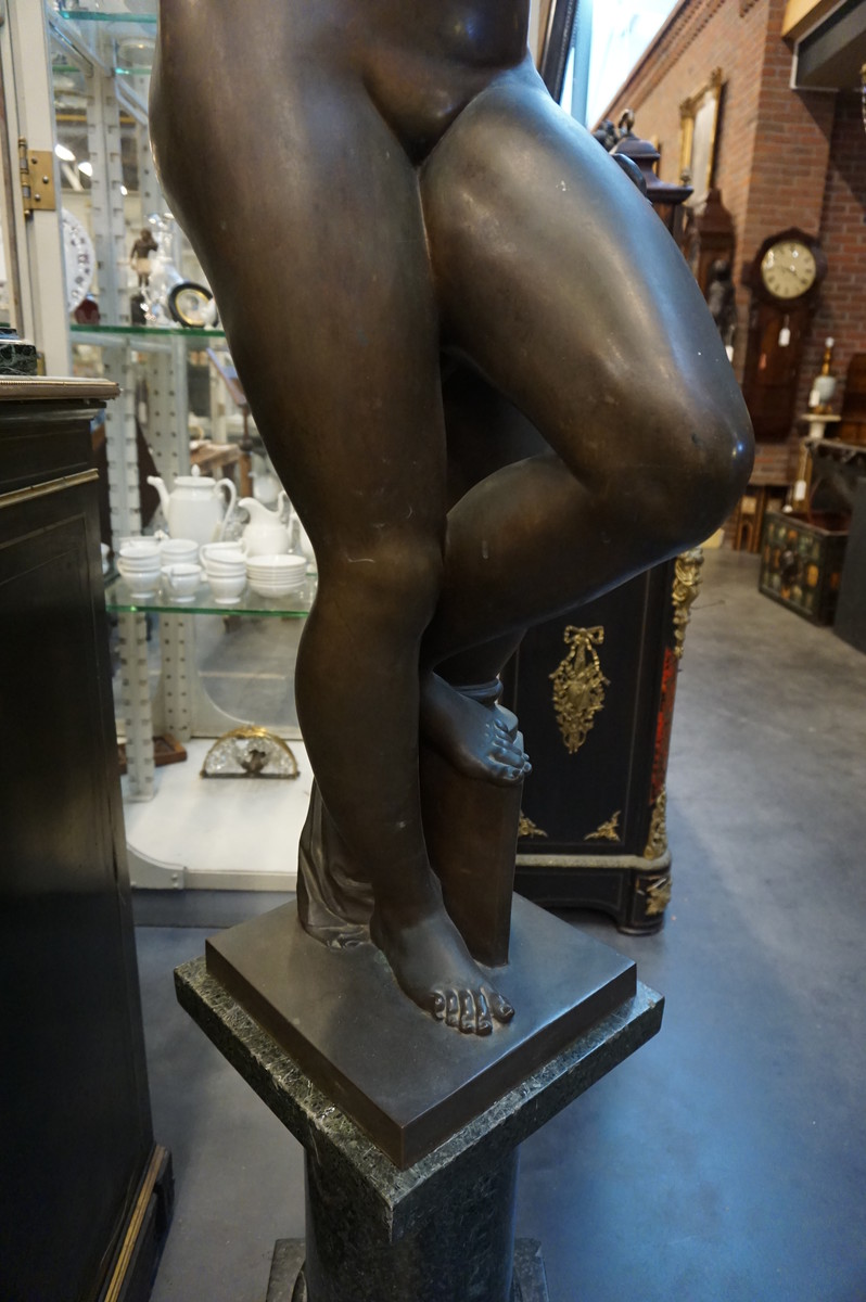 Big bronze nude on marble column