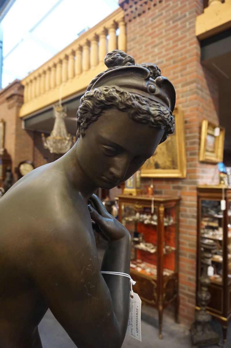 Big bronze nude on marble column