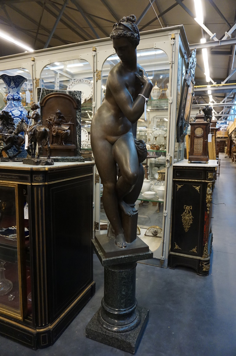 Big bronze nude on marble column